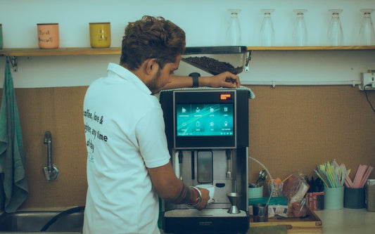 a man standing in front of a coffee machine