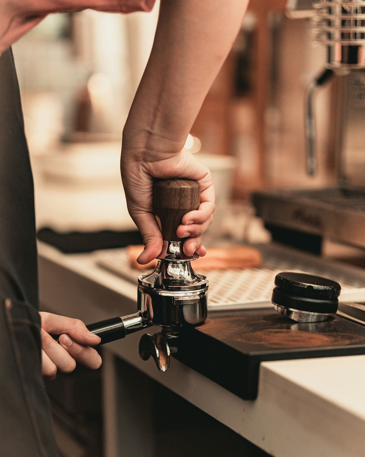 person holding silver and black coffee maker