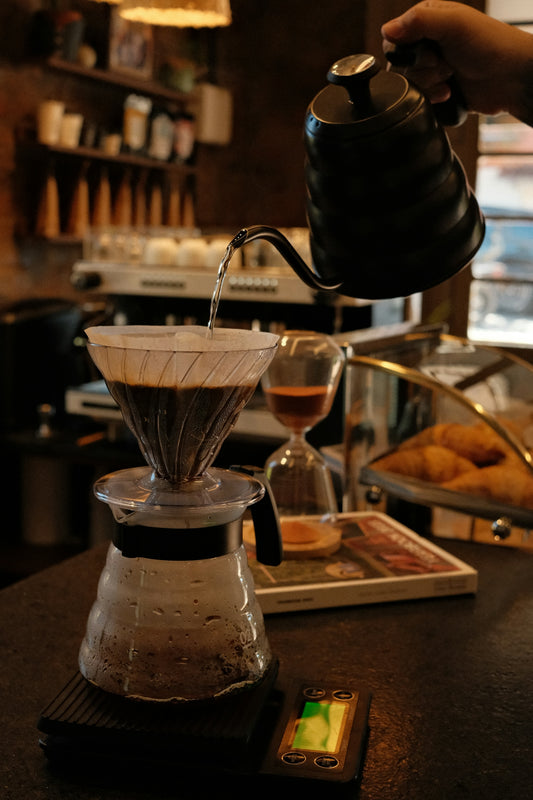 A person pours coffee from a coffee pot