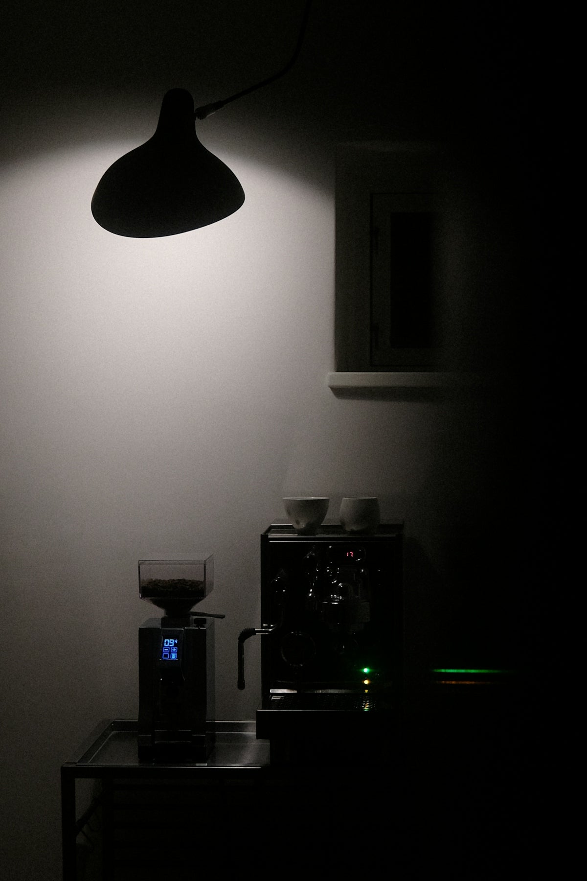 A dark room with a lamp and a coffee maker