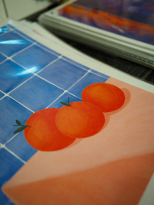 A picture of three tomatoes on a blue tiled counter