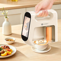 Hand using Evebot Smart portable printer to create a bear design on coffee.